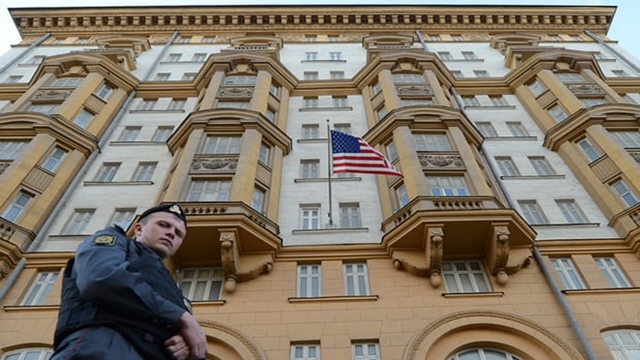 Russian police officer patrolling a street in front of the US embassy in Moscow