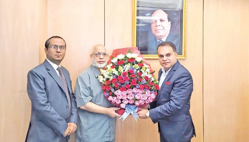 Anwar Group of Industries Chairman Manwar Hossain hands over flower bouquet to Hossain Akhtar at a function recently
