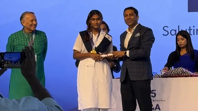 Samiha binte Salahuddin, daughter of State Minister for Fisheries and Livestock Sultan Salahuddin Tuku, receives an award from State Minister for Education Bobby Hajjaj.